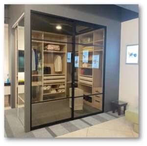 Stylish walk-in closet with glass doors, custom shelves, and organized storage for clothes and accessories.